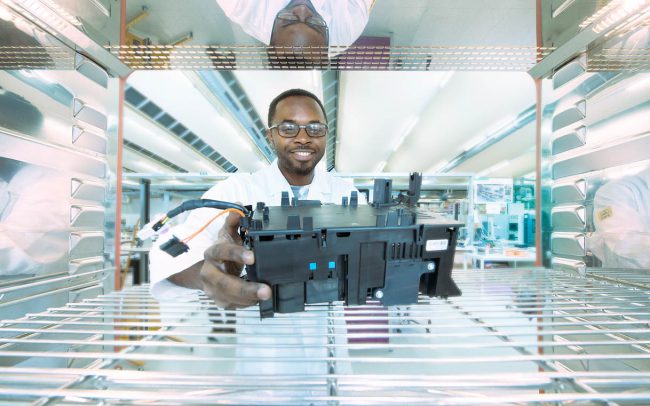 Mitarbeiter legt Bauteil in Klimaschrank © Industriefotograf Thomas L. Fischer