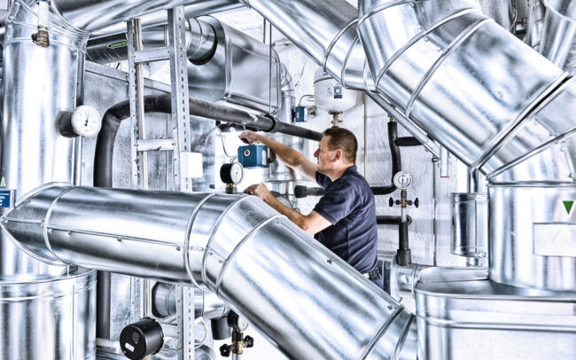 Arbeiter führt Wartungsarbeiten in Klimazentrale durch