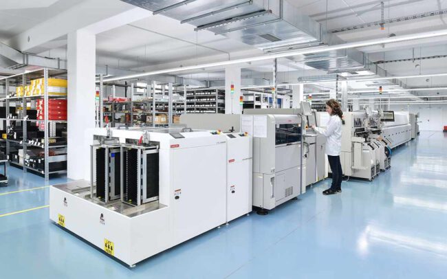 Industriefotografie Mitarbeiterin in Produktionshalle für elektronische Bauteile © Industriefotograf Thomas L. Fischer